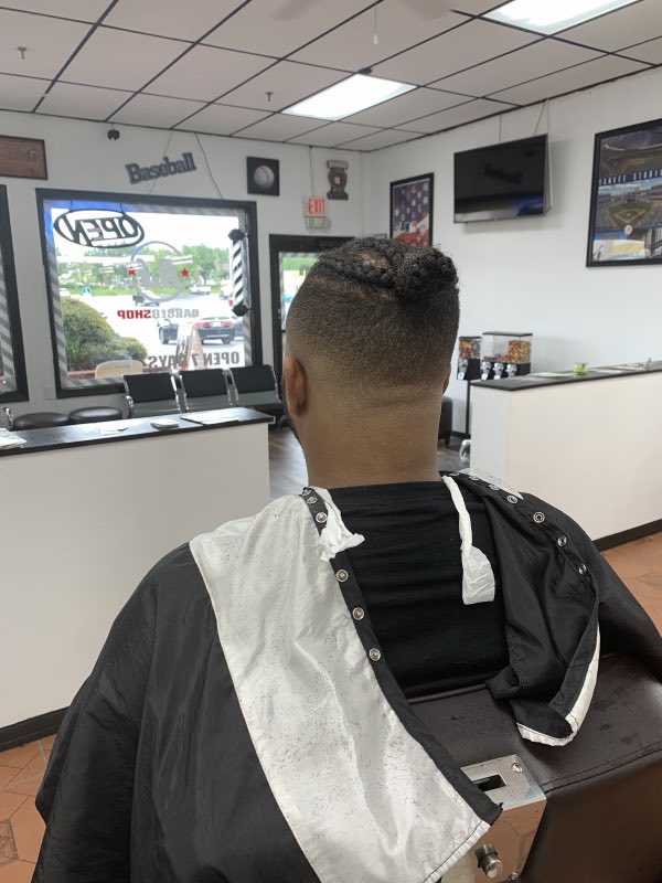 Back view of a fresh cut with braids on top and shaved sides