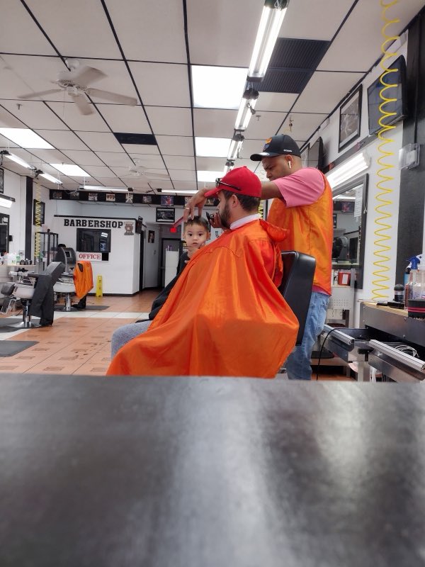 A child getting a haircut at NJ Barbershop